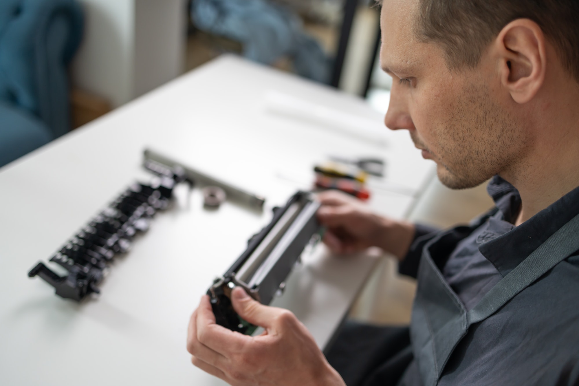 Specialist repairs the printer cartridge, fuser unit close-up. printer repair technician.